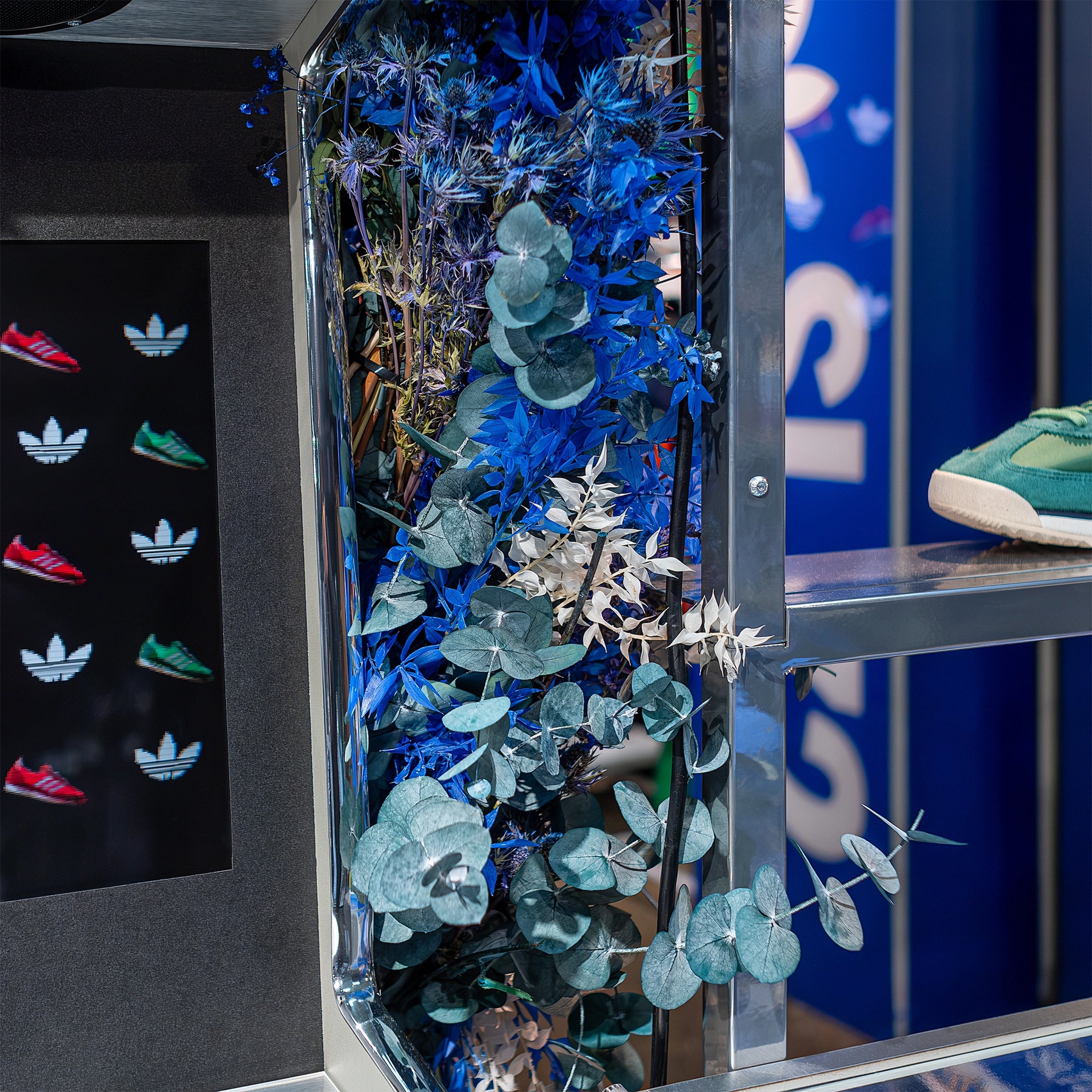 This blue-themed flower arrangement is part of the floral design by Amaranté London for the Adidas Bond Street store to celebrate the SL72 event. It features lush green and blue foliage that reflects the stylish, energetic Adidas brand.