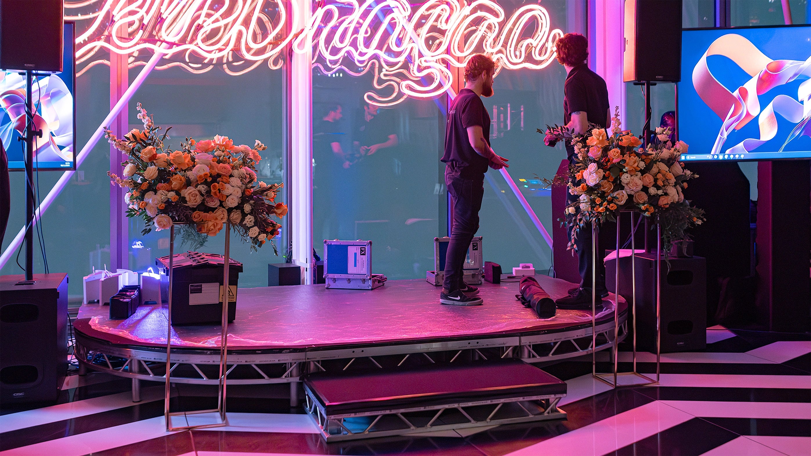 Elegant floral displays decorate the bar area; 2 free-standing plinths with lush orange and cream roses complemented by greenery create a sophisticated atmosphere for guests to enjoy at the EasyJet annual partner event in London.