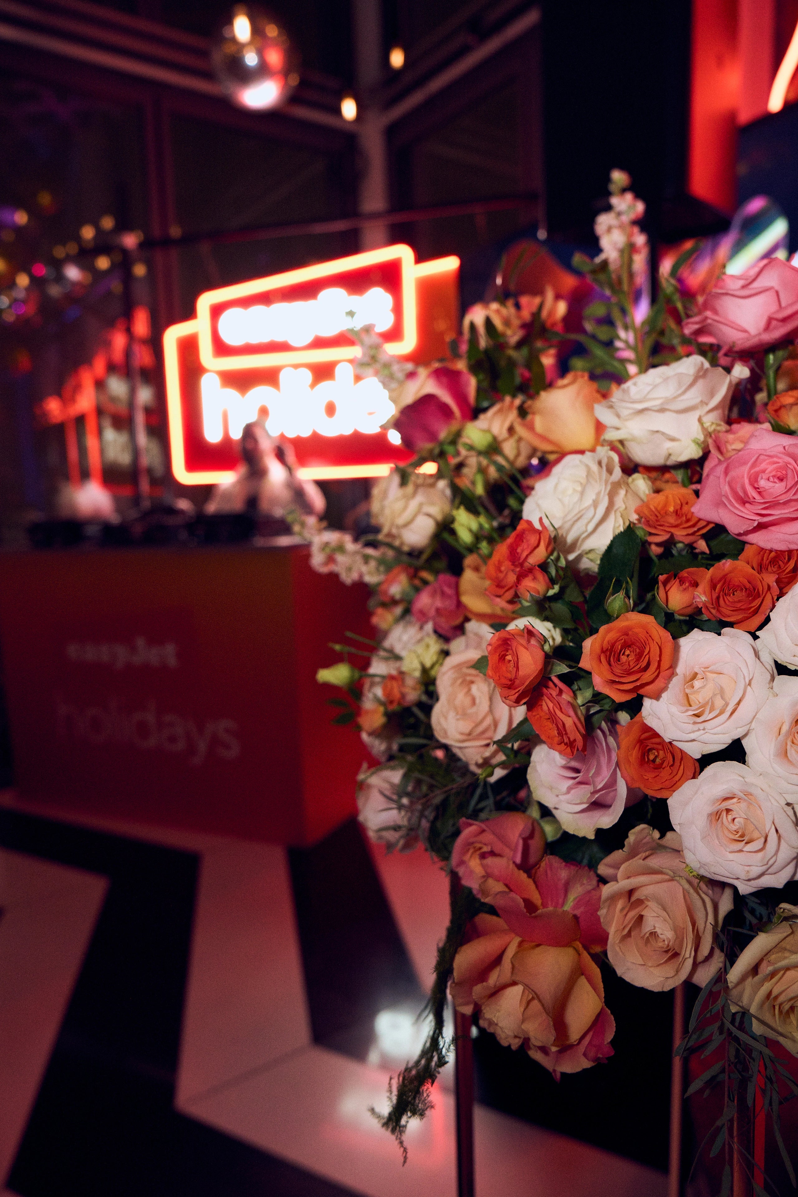 A very large floral arrangement featuring warm orange and soft cream roses paired with greenery, a perfect balance of colours of The EasyJet Brand and The SushiSamba location in central in London.