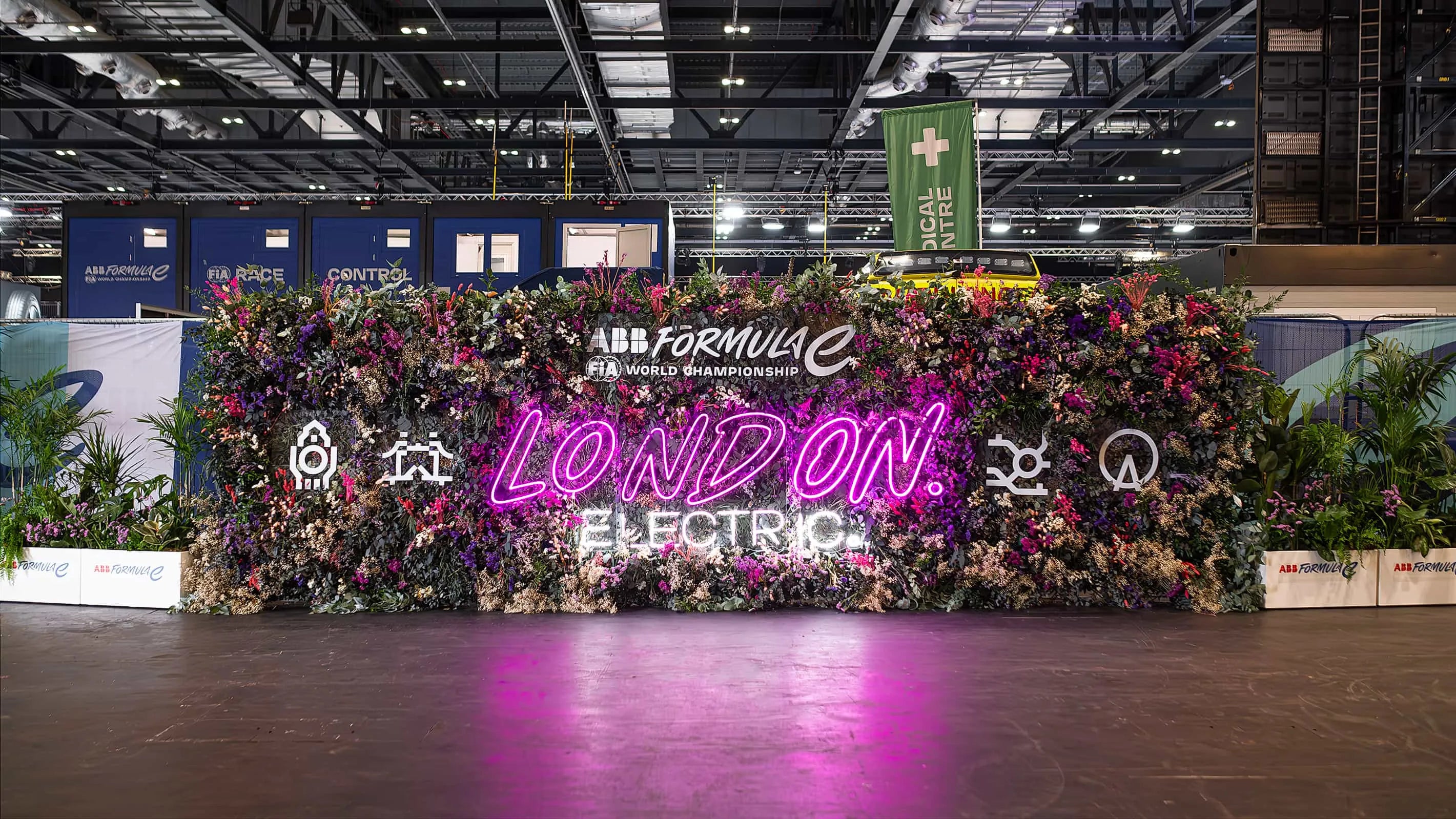 An expansive and intense floral installation at the Formula E London Electric event features a grand display of multicoloured flowers and bespoke lighting - Amaranté London.