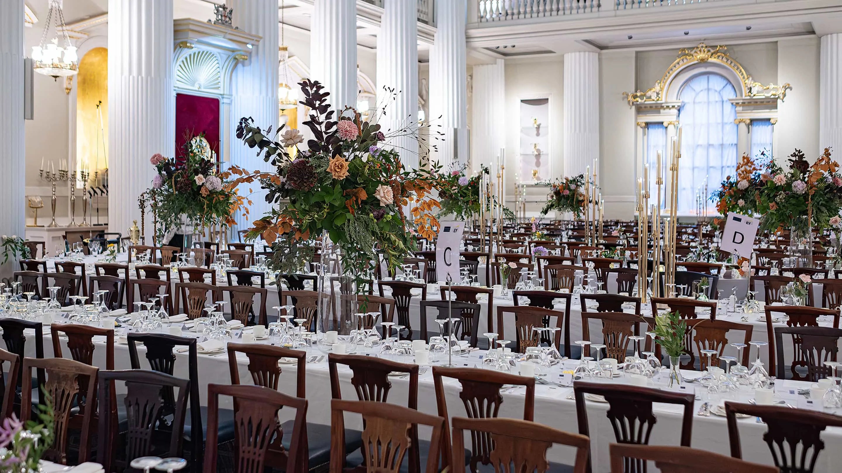 Elegant long tables adorned with exquisite floral arrangements designed, created and delivered by Amaranté London