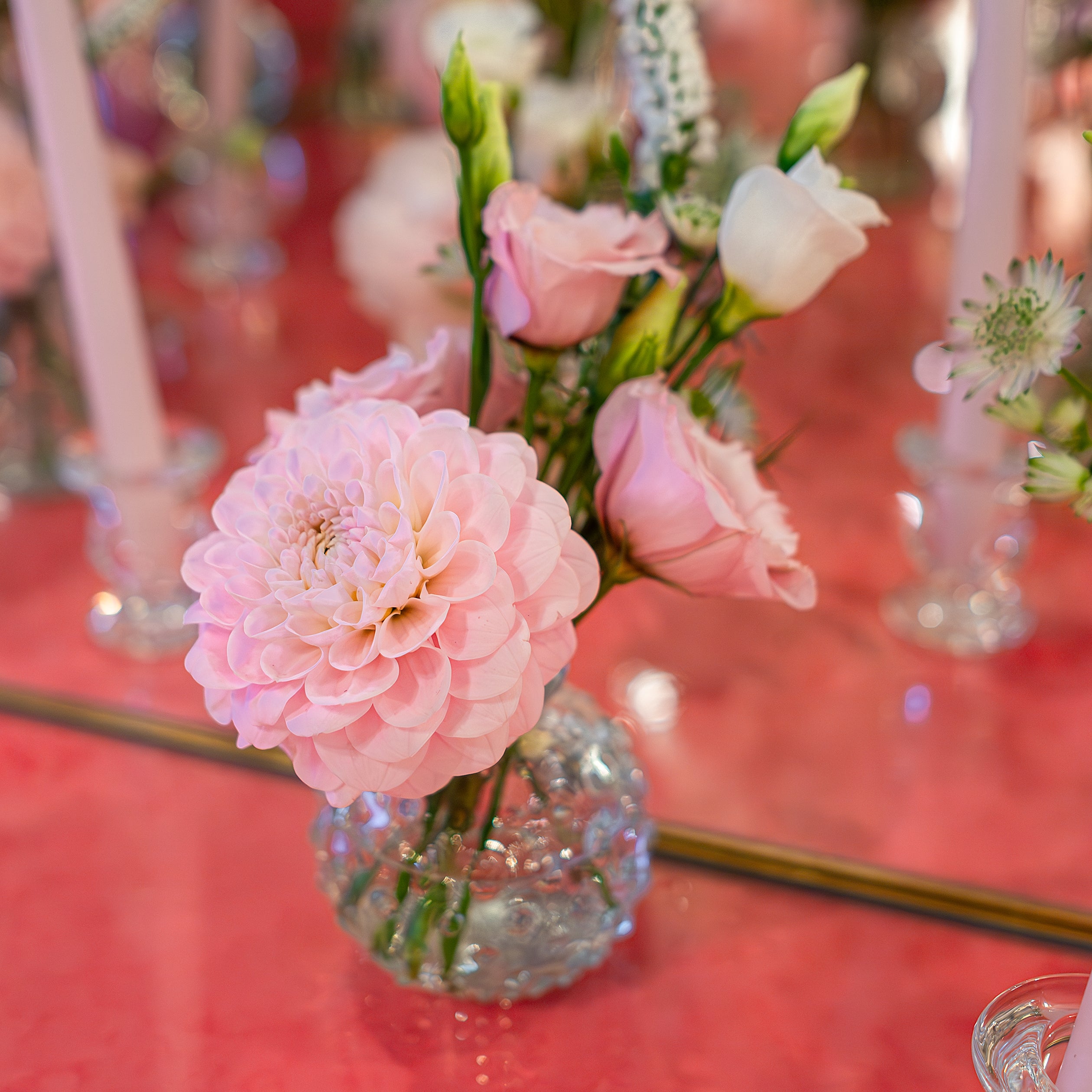 A delicate pink dahlia arrangement in a clear glass vase enhances the elegant table setting for the Sensai product launch - Amaranté London