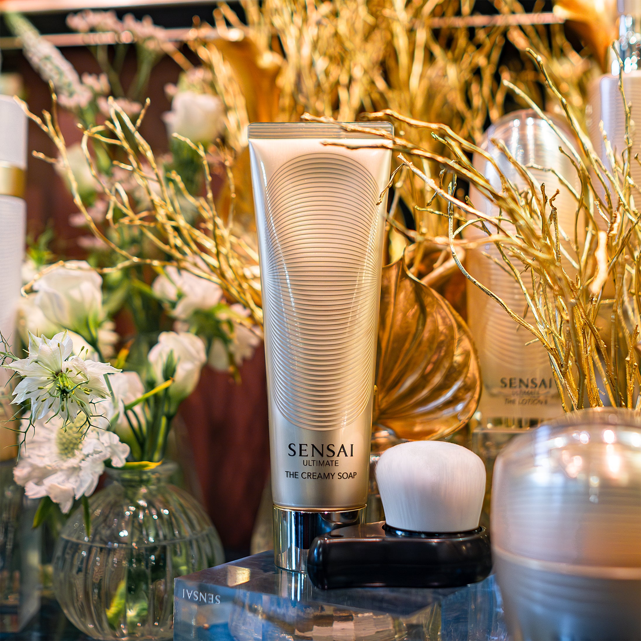 Sensai Ultimate The Creamy Soap is beautifully presented amidst golden flower arrangements by event florist Amarante London, adding luxury and sophistication to the Sensai product launch in London.