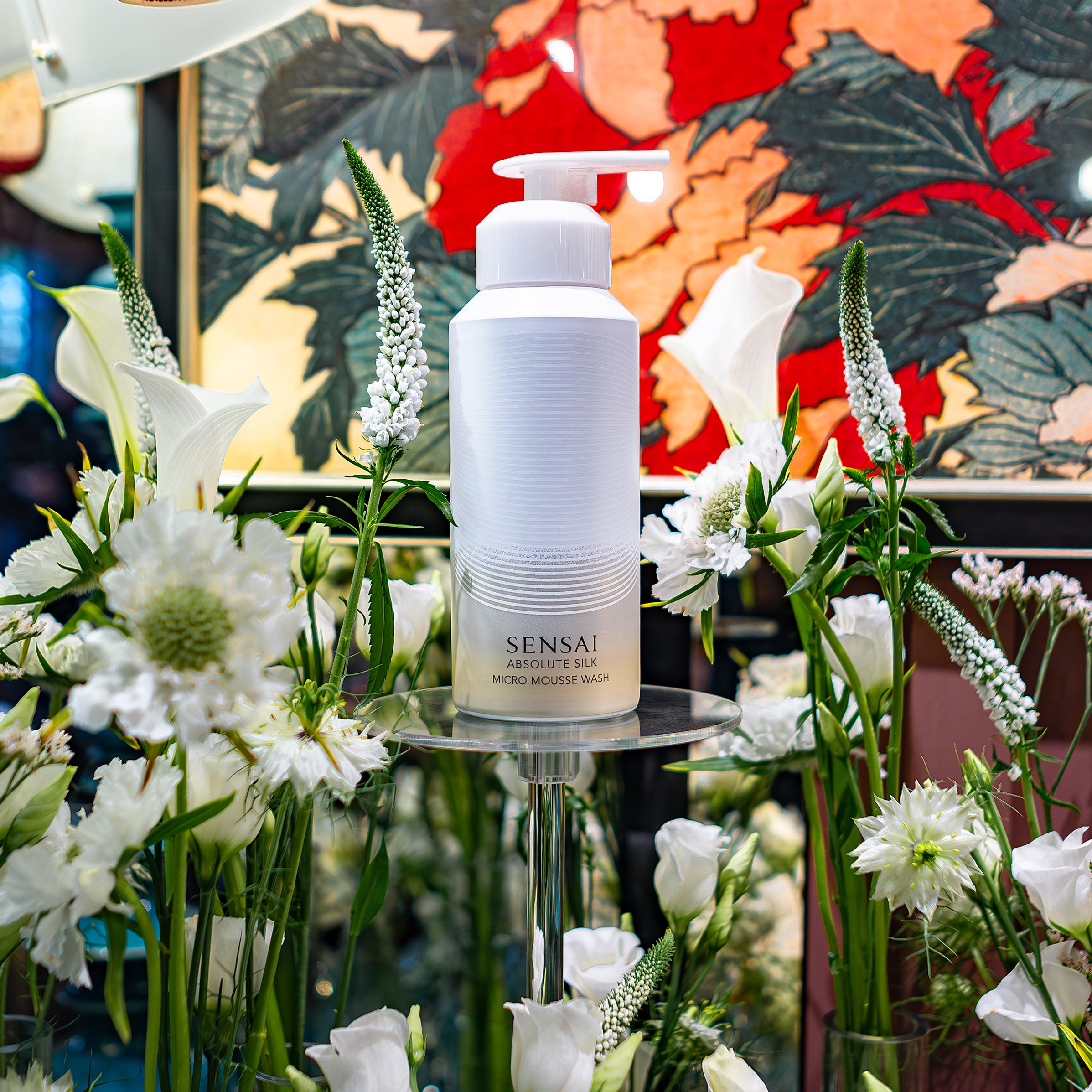 Image showcasing Sensai Absolute Silk Micro Mousse Wash amidst white flower arrangements designed by Amarante London for the product launch.