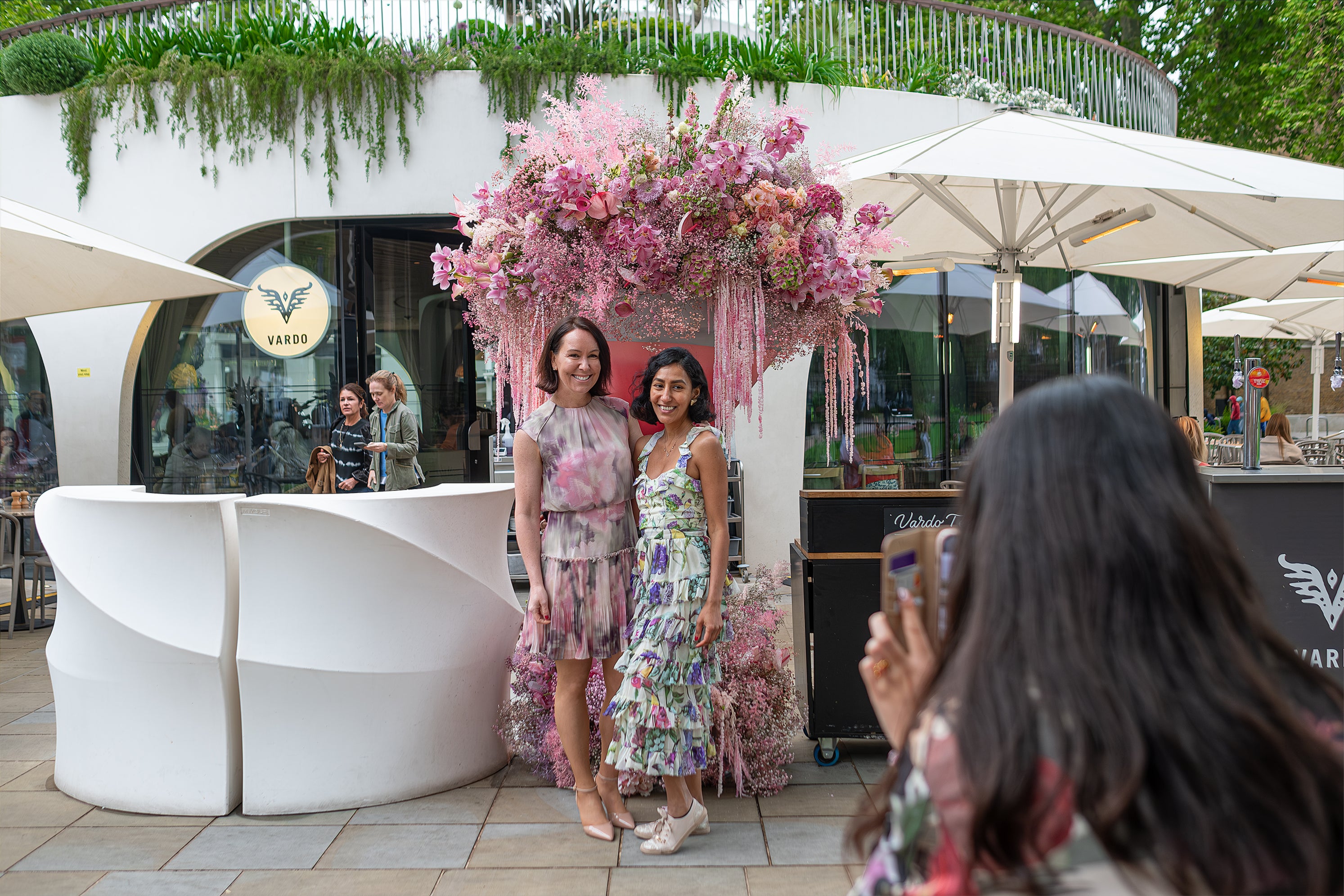 A luxurious pink floral arrangement at Vardo in Chelsea, featuring a blend of roses, orchids, and hanging amaranthus, enhanced the vibrant atmosphere at the Chelsea in Blooms event. A giant pink cocktail Glass contains the pink floral arrangement and is the ideal location for a selfie.