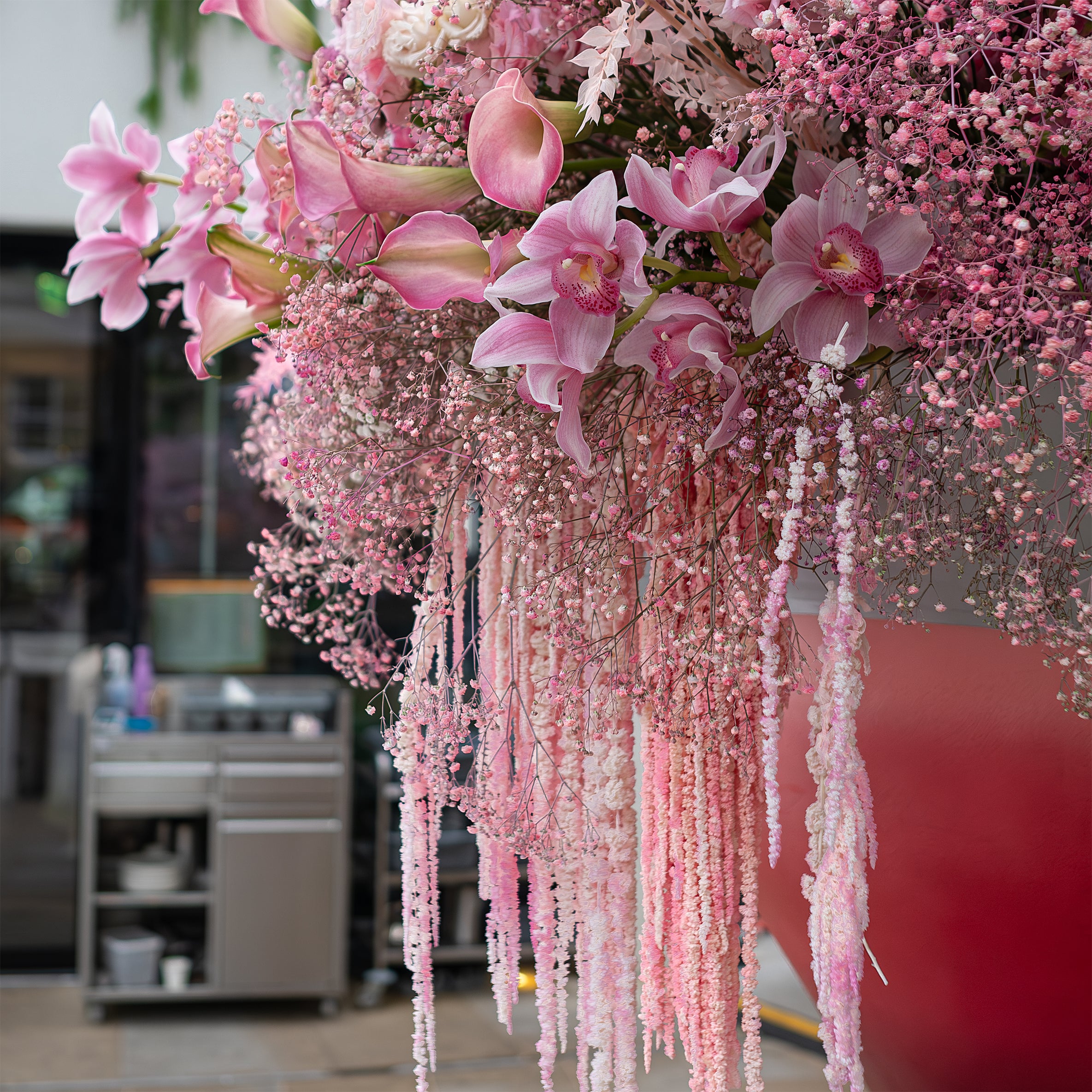 This is a close-up view of the bespoke luxury floral installation at Vardo. It features a giant cocktail-inspired arrangement with pink flowers and greenery, reflecting a festive and elegant corporate event setting - Amaranté London