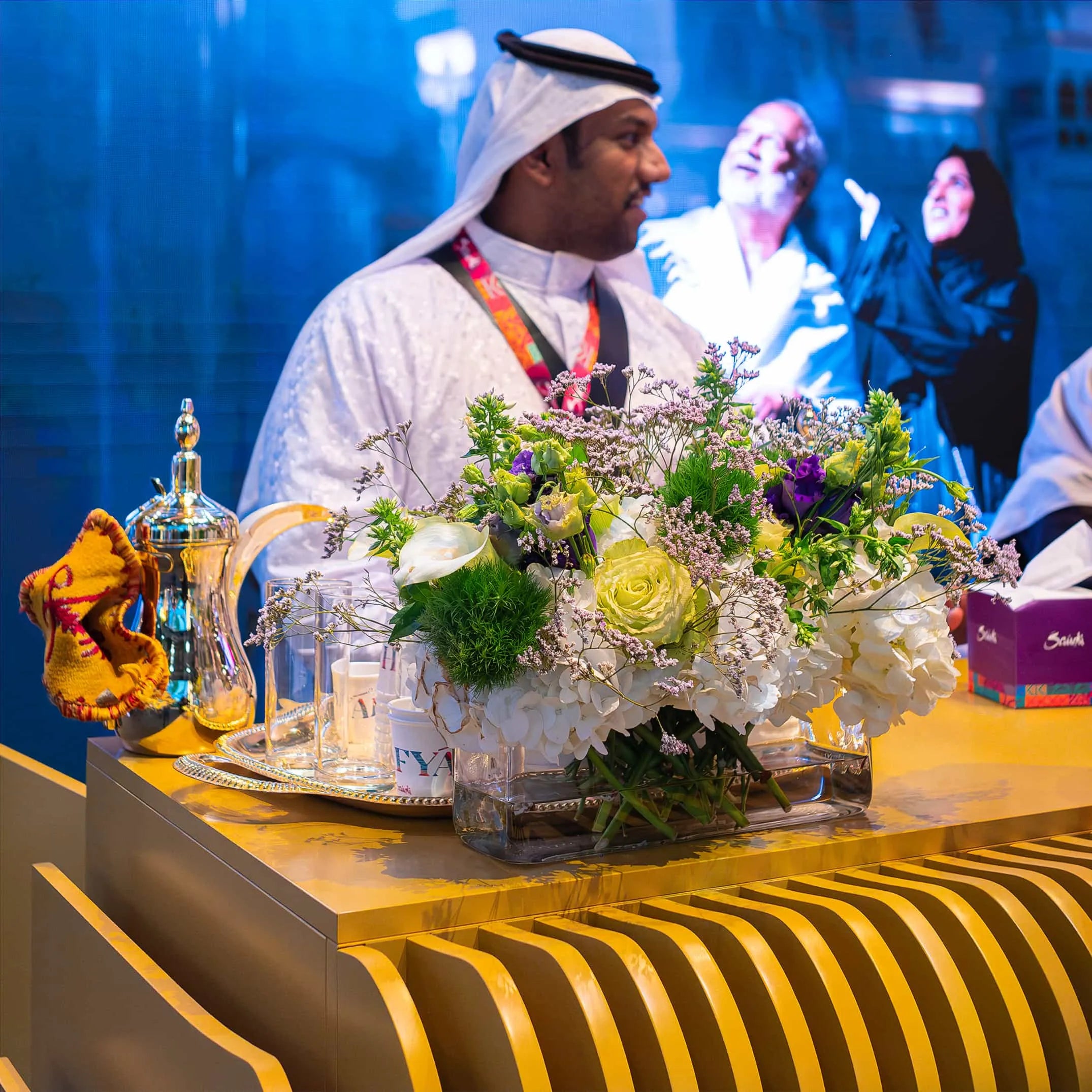 Luxurious mixed floral arrangement by Amaranté London at WTM, with a traditional Arabic coffee set, infusing cultural elegance.