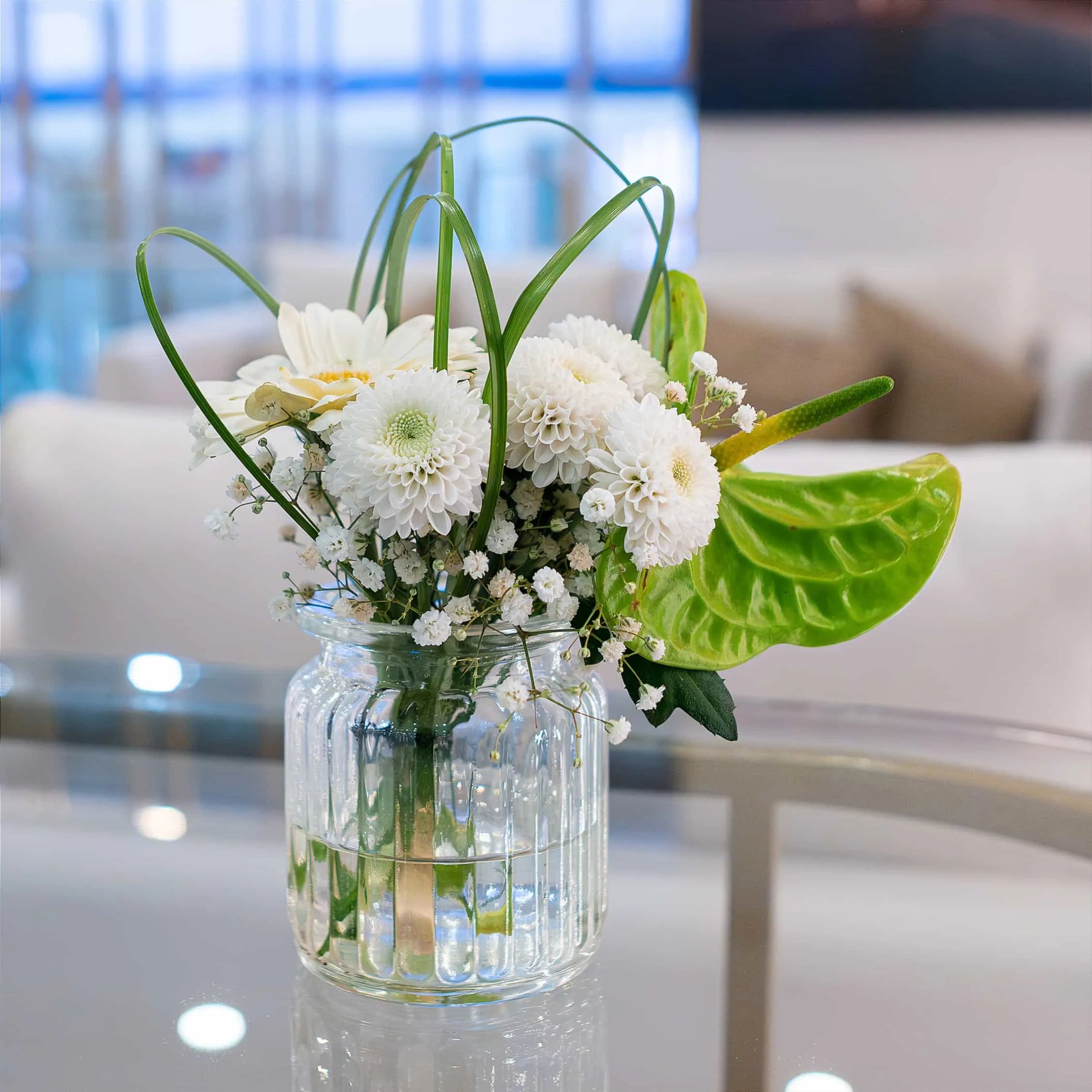 Pure white fresh flower bouquet, with white daisies at WTM in London, enhancing the corporate lounge area of this location of the event.